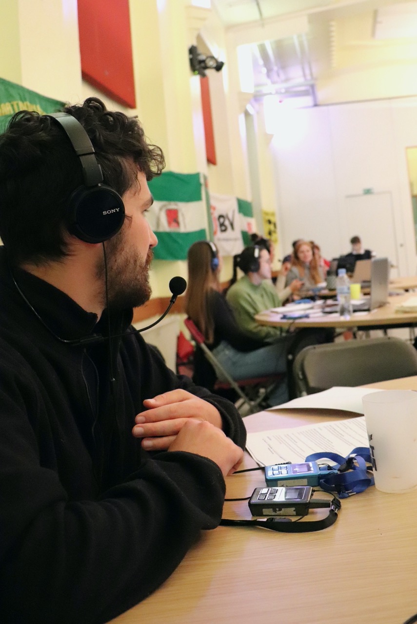 Luc, assis, interprète à l'aide d'un bidule.